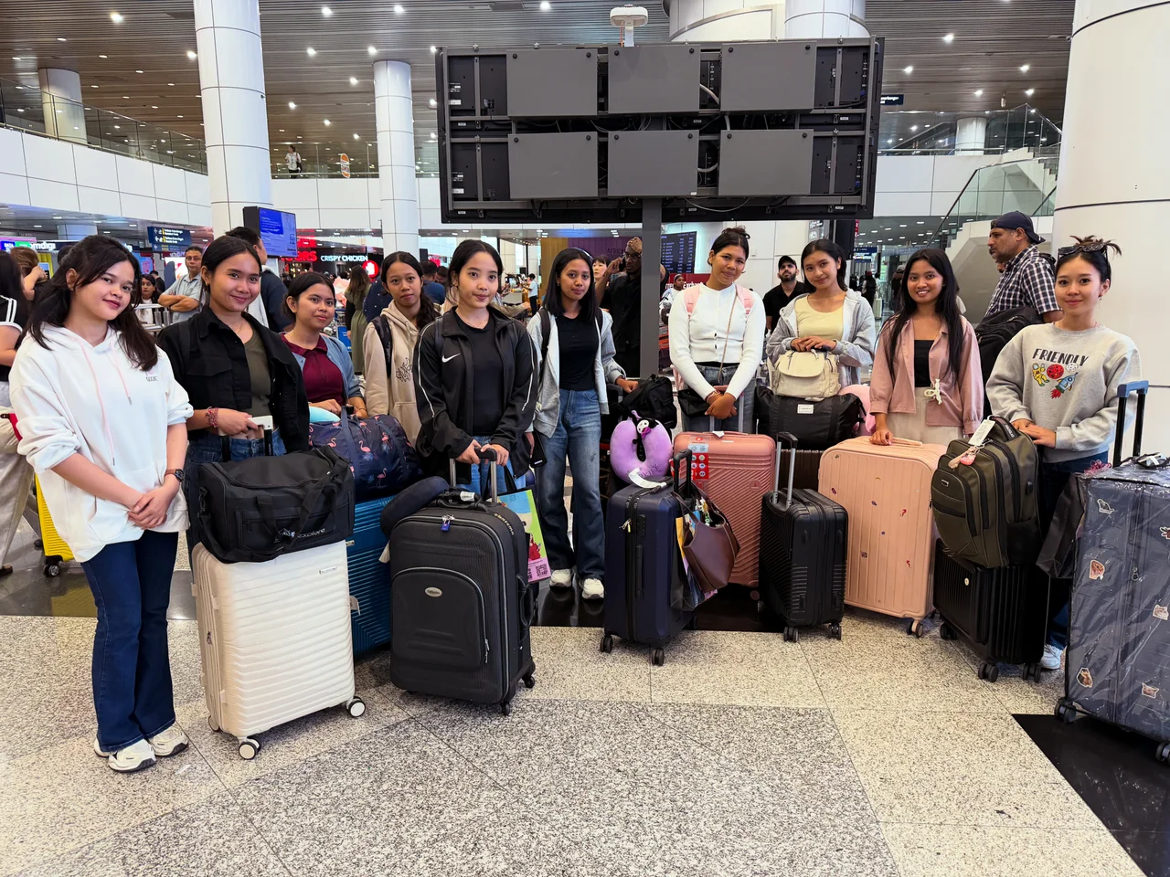 Students with their luggage at an airport pickup in Malaysia
