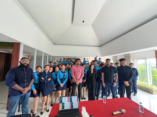 A group of students and visitors gathered beside a presentation table