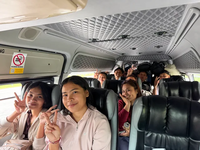 Students smiling together inside a passenger van